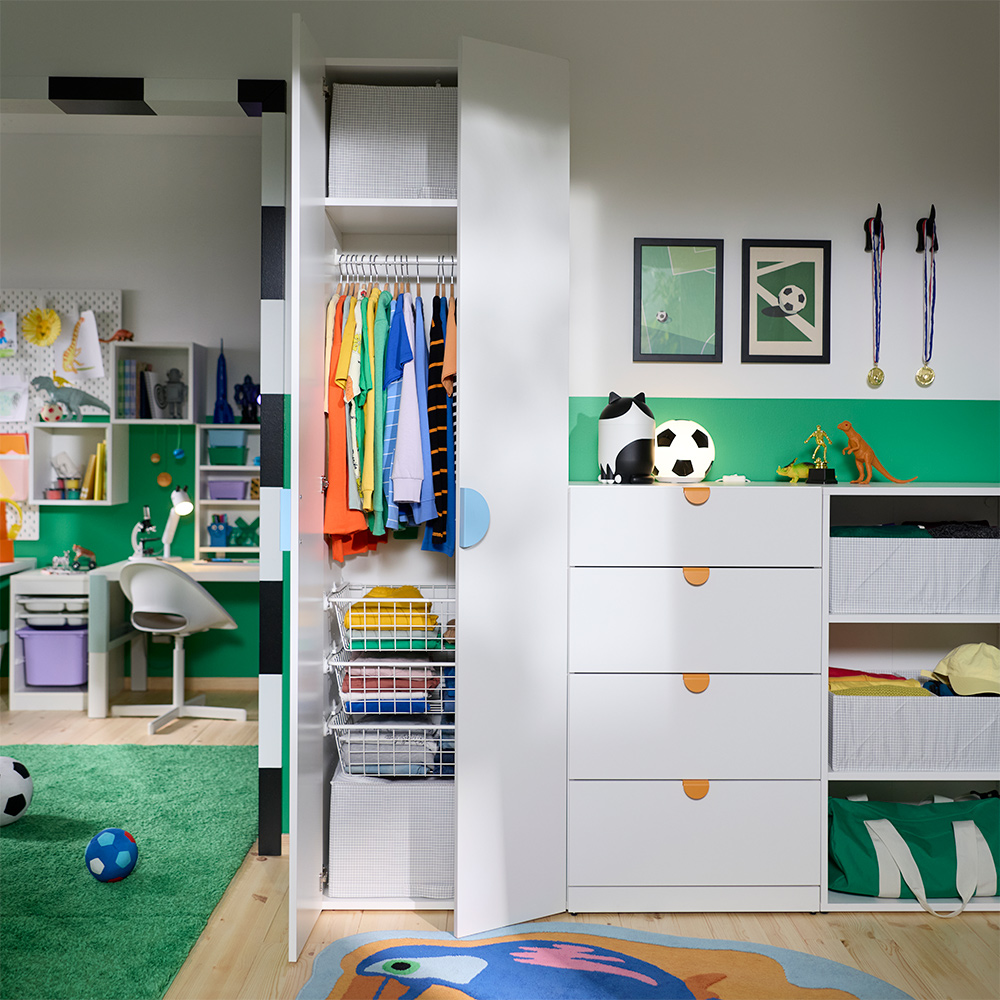A kids’ room with a LASTARE wardrobe combination with storage, hanging rail and drawers next to a workspace and play area.