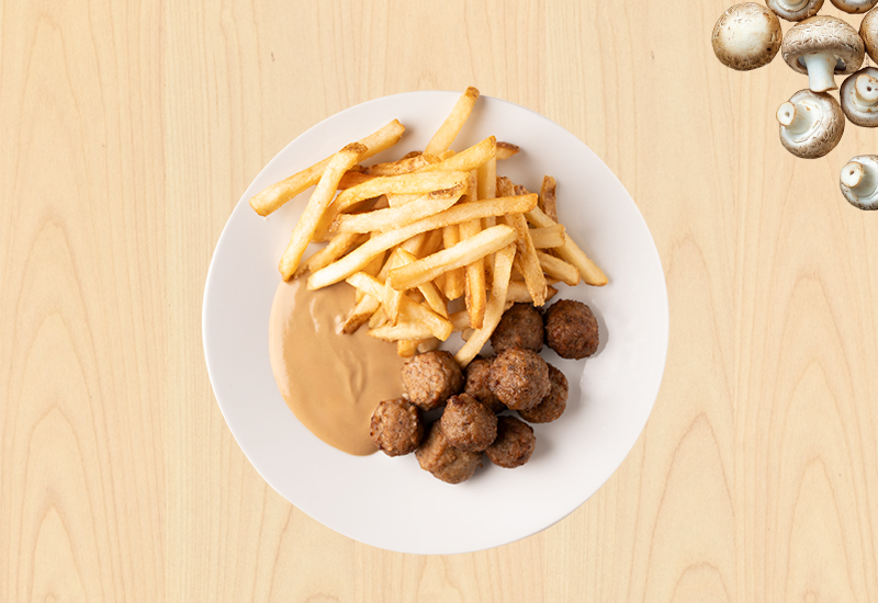 Plato con albóndigas, papas fritas y salsa Savory sobre fondo de madera clara.