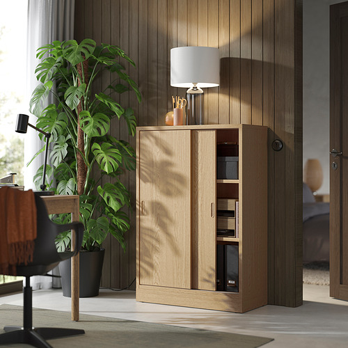 Mueble de madera moderno - TONSTAD, marrón claro, puertas correderas, estantes ajustables, lámpara, planta.