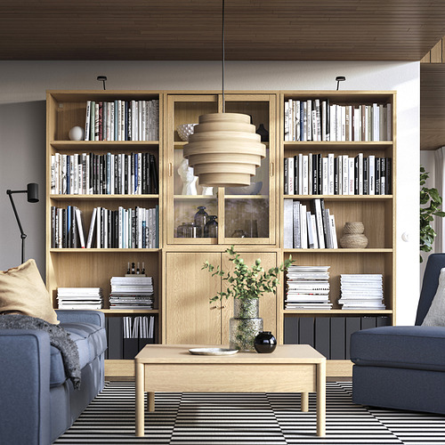 Sala de estar con estanterías, libros y decoración TONSTAD. Muebles azules y grises, mesa de centro con bandeja y planta.