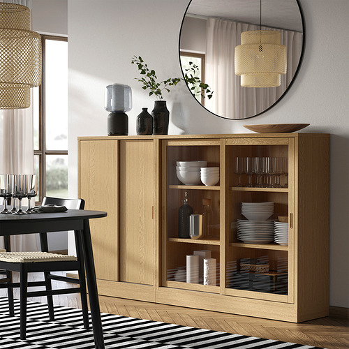Mueble de comedor de madera con puertas correderas y luz acogedora, cuencos y vasos en el interior.