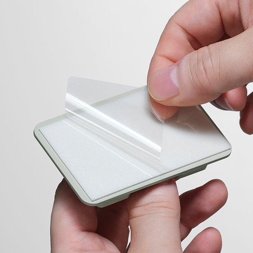 Persona sosteniendo un elegante cubo de basura plateado con tapa transparente, enfatizando su diseño moderno y limpio.