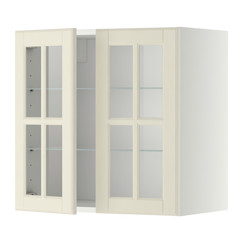 Un armario de pared METOD de color crema con puertas de cristal. Tiene una forma rectangular y un diseño tradicional, con estantes ajustables.