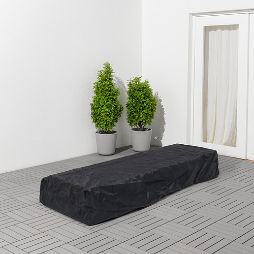 Cubierta impermeable negra TOSTERÖ en cubierta con plantas, cerca de la puerta blanca. Se adapta a silla reclinable.