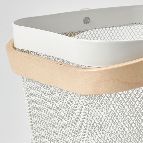 Detalle de elegante cesta de almacenamiento con orificios de ventilación, asa de madera clara.