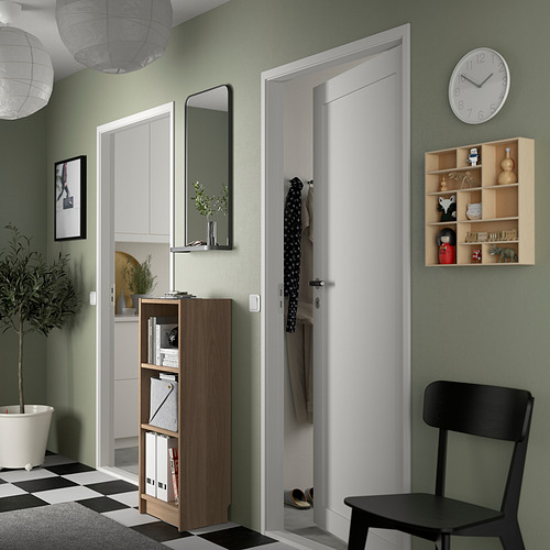 Sala de estar moderna con estantería BILLY, silla negra, reloj y decoración.