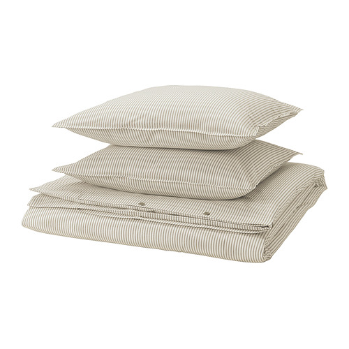 Pila de tres almohadas de algodón a rayas beige, cuidadosamente dobladas.