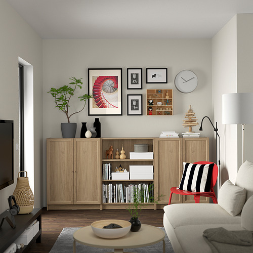 Sala de estar con librería Billy, sofá, mesa de centro, galería de arte, lámpara y planta.