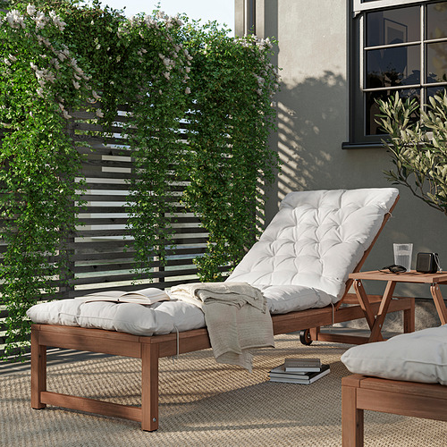 Salón exterior moderno: madera, cojín blanco, plantas verdes, zona gris.