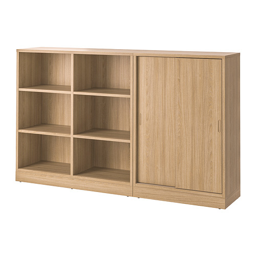 Un mueble de almacenaje TONSTAD en acabado roble con secciones abiertas y cerradas. Cuenta con estantes ajustables y puerta corredera.
