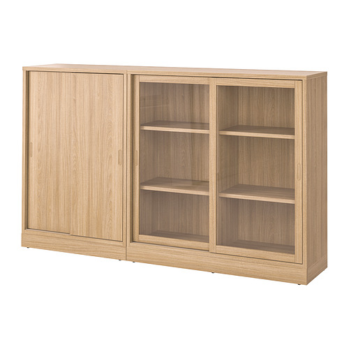 Un mueble de almacenaje TONSTAD de color marrón claro con puertas correderas. Cuenta con estantes ajustables y un diseño clásico y moderno.