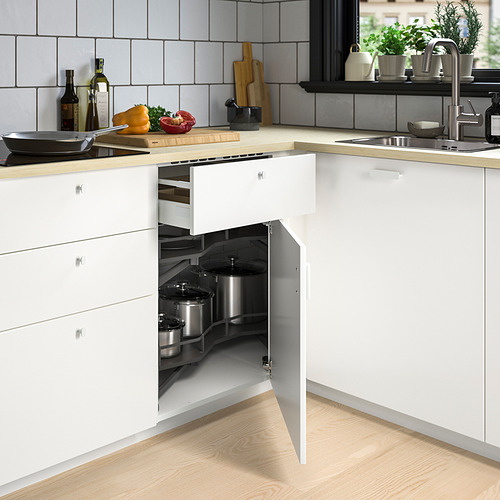 Moderno mueble de cocina blanco con estantes de esquina incorporados que sostienen ollas, ahorrando espacio de manera eficiente.