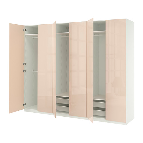 Moderno armario PAX de color rosa claro con puertas abiertas que muestran estantes y cajones.