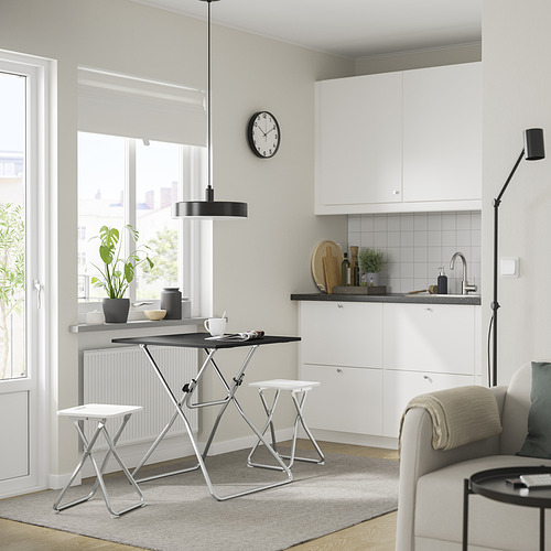 Cocina moderna con mesa plegable GUNDE, decoración blanca y reloj negro.