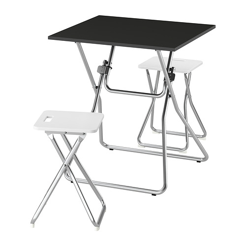 Un juego de mesa plegable GUNDE. Incluye una mesa negra y dos taburetes blancos. Los marcos de metal son plateados para mayor durabilidad y fácil almacenamiento.