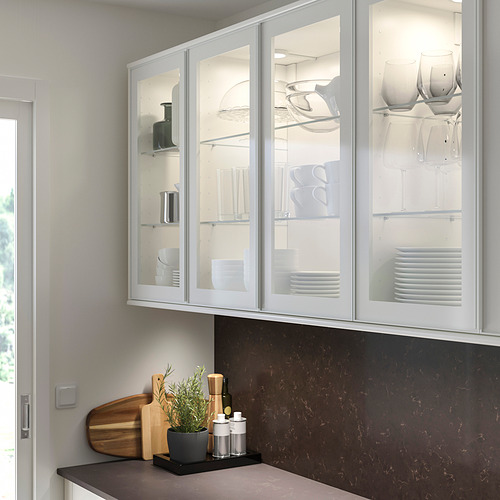 Cocina con armarios HEJSTA blancos. Platos, cuencos, copas de vino, plantas, tablas de cortar, aceites.