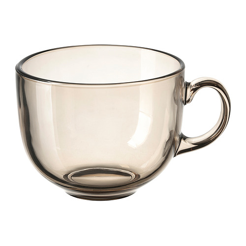 Un vaso pequeño de cristal gris con asa para beber. Forma redonda y diseño transparente.