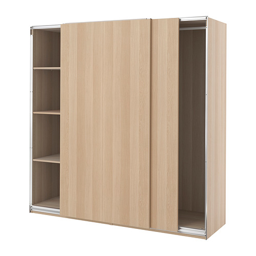 Un armario PAX de madera de color claro con puertas correderas y tres estantes visibles.