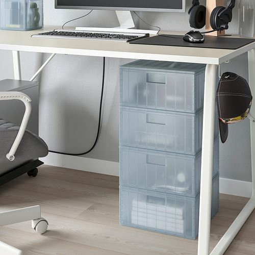 Limpie los cajones etiquetados debajo del monitor, almacene artículos pequeños de manera eficiente. Silla de oficina gris cerca.