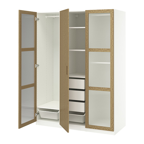 Armario moderno PAX en blanco con molduras de madera, con puertas de cristal, estantes y una cesta de malla en el interior.