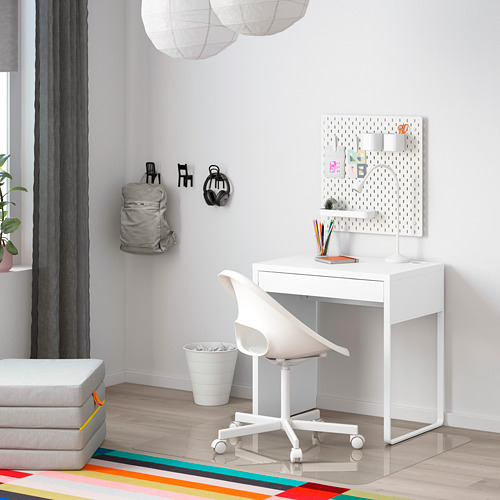 Configuración de escritorio MICKE en una habitación luminosa, diseño moderno y simple con cajón, silla, organizador y accesorios montados en la pared.