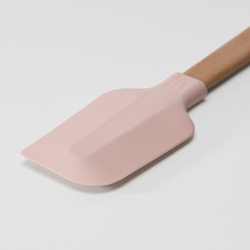 Una espátula de silicona rosa con mango de madera, diseñada para hornear, con un borde liso para raspar la masa sin costuras.