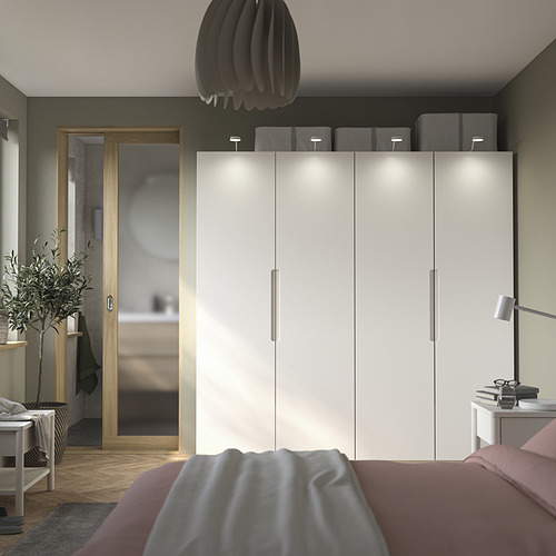 Dormitorio moderno con puerta de armario TONSTAD pax blanco, tiradores integrados. Incluye cama con manta gris y mesita auxiliar minimalista con lámpara.