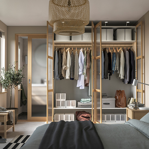 Armario moderno con ropa colgante, estantes y una elegante lámpara colgante. Parte de un dormitorio organizado en suite.
