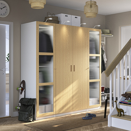Armario de madera PAX con puertas de cristal, juguetes en escaleras blancas, estanterías con iluminación led.