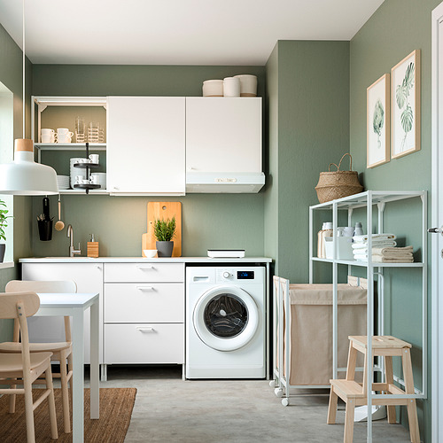 Modernos muebles de almacenaje ENHET blancos en sala verde con estanterías abiertas, lavadora y bolsa de lavandería, diseño minimalista.