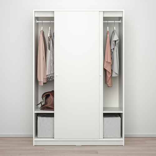 Armario blanco con puertas correderas, dos secciones para colgar, estante con ropa doblada, estante inferior con cesta, ropa en perchas.