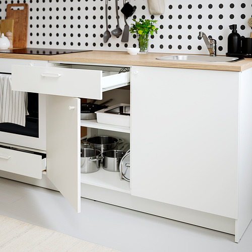 Cocina moderna con armarios blancos, accesorios en ollas favoritas, y encimera de madera, fregadero, con distribuciones sencillas y prácticas.