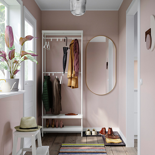 Acogedora entrada con perchero blanco MACKAPÄR, espejo redondo y alfombra de rayas multicolor.