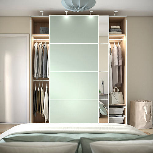 Dormitorio con armario PAX, puertas correderas, perchas y estantes de almacenamiento.