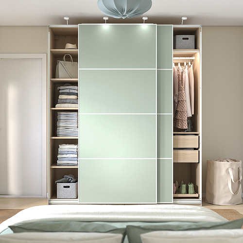 Dormitorio moderno con armario PAX verde menta e iluminación interna.