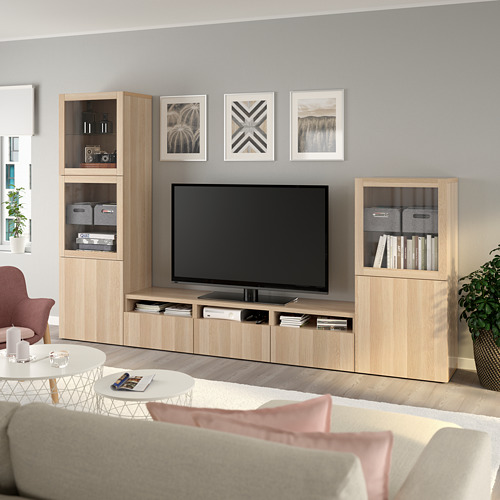 Sala de estar moderna con almacenamiento de TV marrón claro, TV, sofá, mesa de café y detalles en rosa.
