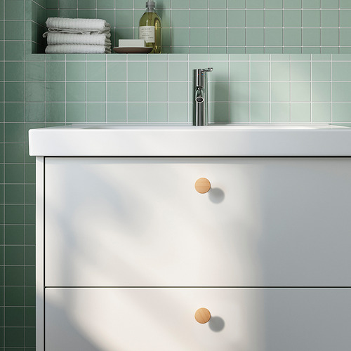 Baño moderno con lavabo blanco y azulejos verdes.