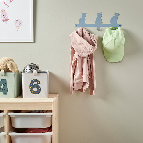 Espacio para niños con ganchos para abrigos en forma de gato que sostienen una sudadera con capucha rosa y una gorra de béisbol verde; Abajo, contenedores de almacenamiento con juguetes y animales de peluche.