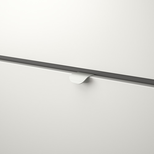 Primer plano de un tirador blanco y elegante en un armario moderno, que muestra su superficie lisa y su diseño limpio.