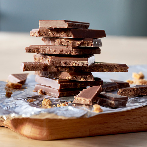 Barras de chocolate apiladas con migas de jengibre crujientes; Textura cremosa y crujiente.