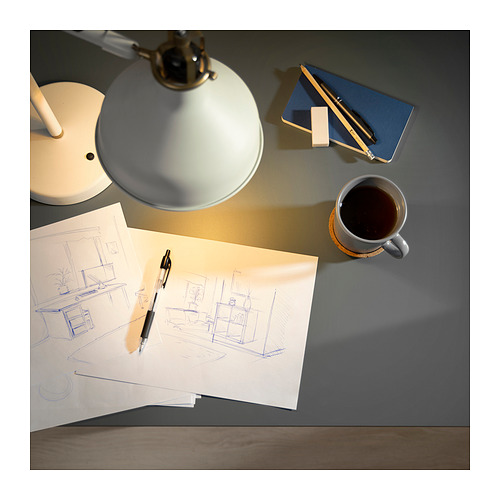 Escritorio con lámpara, cuaderno, café, boceto - espacio de trabajo creativo.