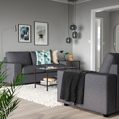 Sala de estar moderna con sofá VIMLE, almohadas geométricas, mesa de centro, lámparas colgantes y arte abstracto.