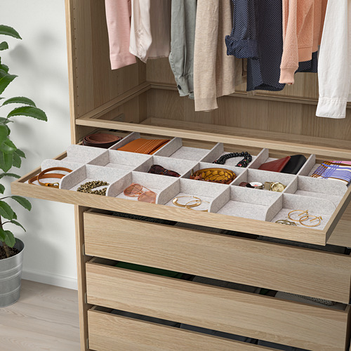 Cajón de madera del armario con bandejas organizadoras grises para guardar cinturones, corbatas y joyas.