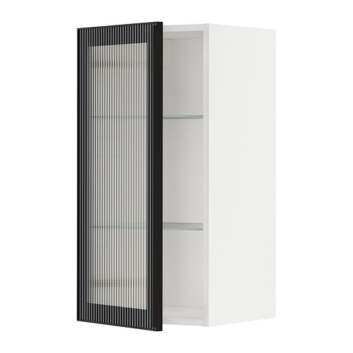Esta imagen muestra un moderno mueble de cocina METOD blanco con una puerta de cristal de caña negra. Es elegante y contemporáneo, diseñado para el almacenamiento en la cocina.