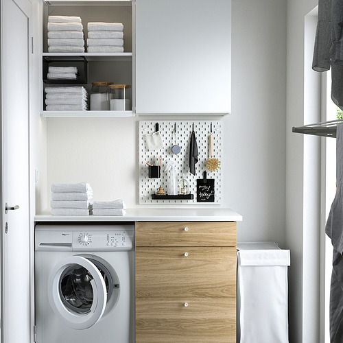 Pequeño tablero perforado blanco de SKÅDIS organizado con herramientas y notas sobre una lavadora en un lavadero.