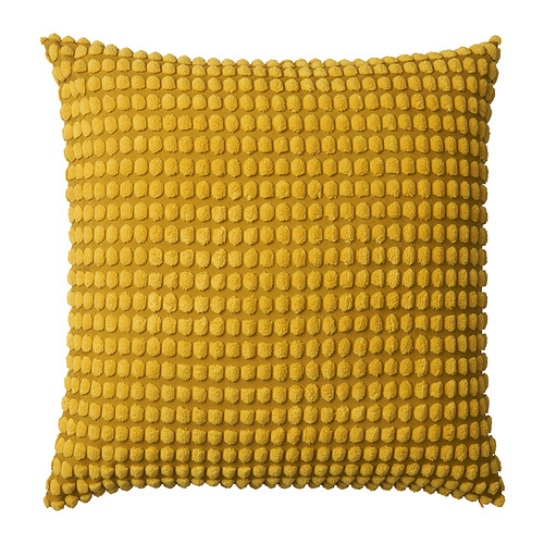 Cojín amarillo, cuadrado, texturizado con bordes de pompones, fabricado en poliéster reciclado.