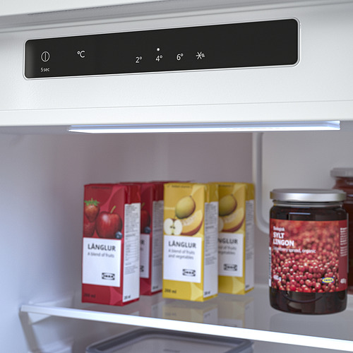Refrigerador moderno con control táctil y pantalla digital que muestra los ajustes de temperatura. En el interior se almacenan tres zumos de frutas y mermelada.