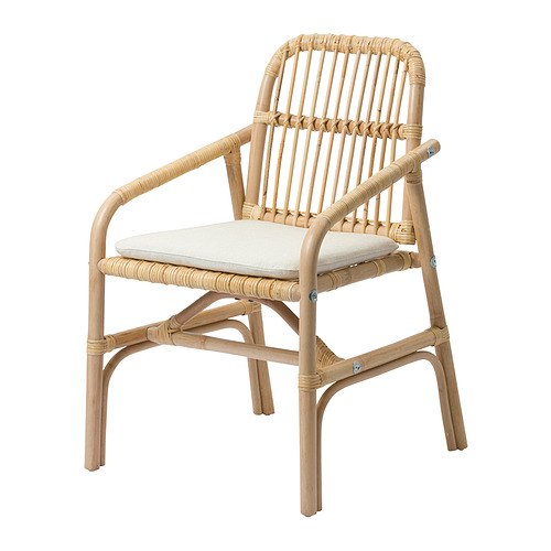 Esta imagen muestra la silla SALNÖ, un sillón de ratán tejido a mano con cojines de color beige claro. Su material natural lo hace único y envejece maravillosamente.