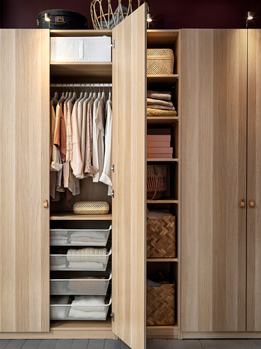 El armario de madera PAX organiza la ropa, utilizando estantes, cajones y espacio para colgar. Bien organizado con acabado natural.