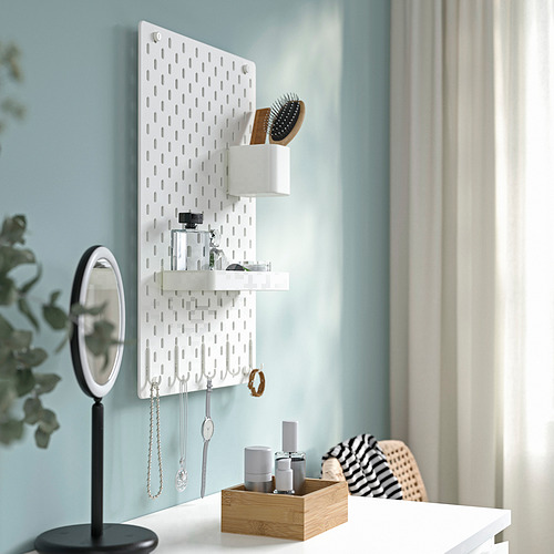El tablero perforado SKÅDIS montado en la pared organiza joyas y artículos de belleza con estantes y ganchos.